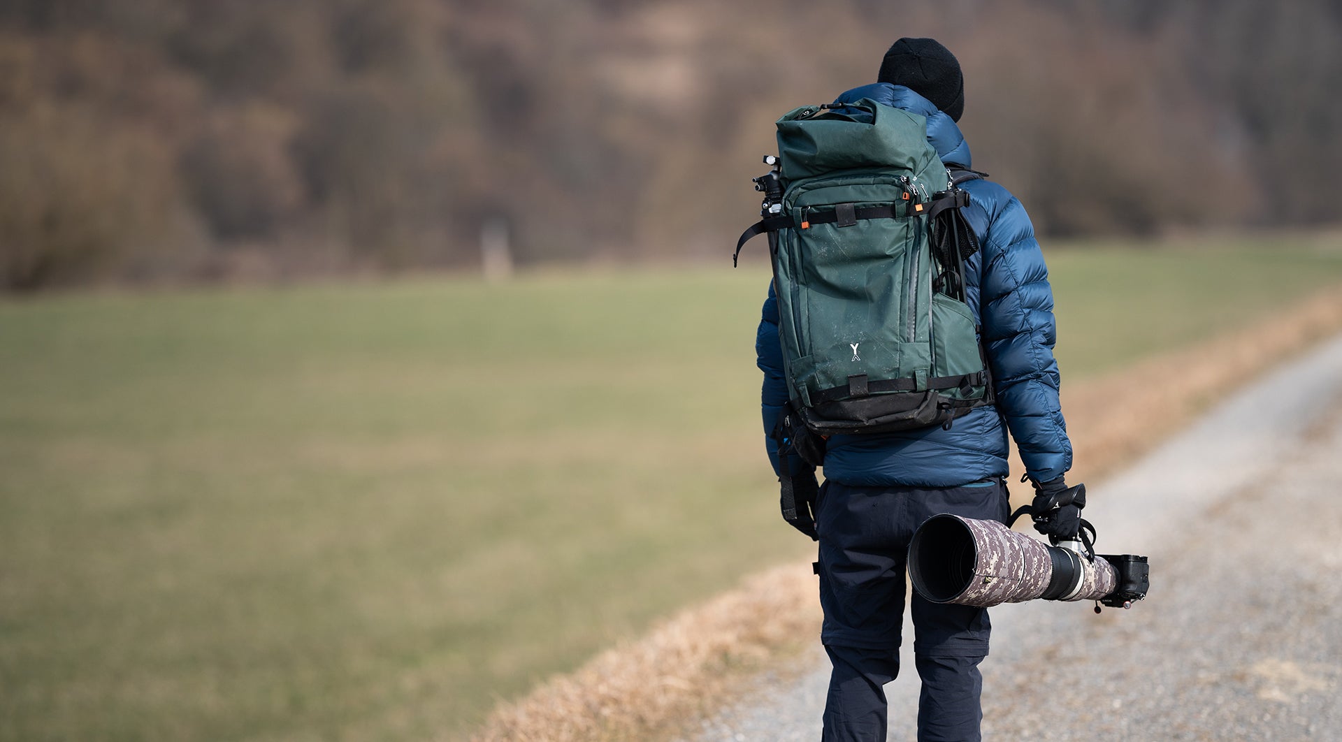 Professional wildlife photographer using NYA-EVO Fjord 60-C backpack with super-telephoto lens in the field